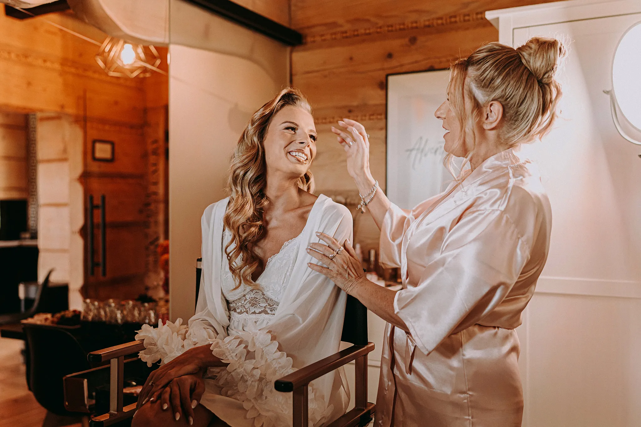 Panna młoda uśmiecha się podczas makijażu w jasnym wnętrzu domku w Hotelu Bajka – fot. Studio Grygierczyk