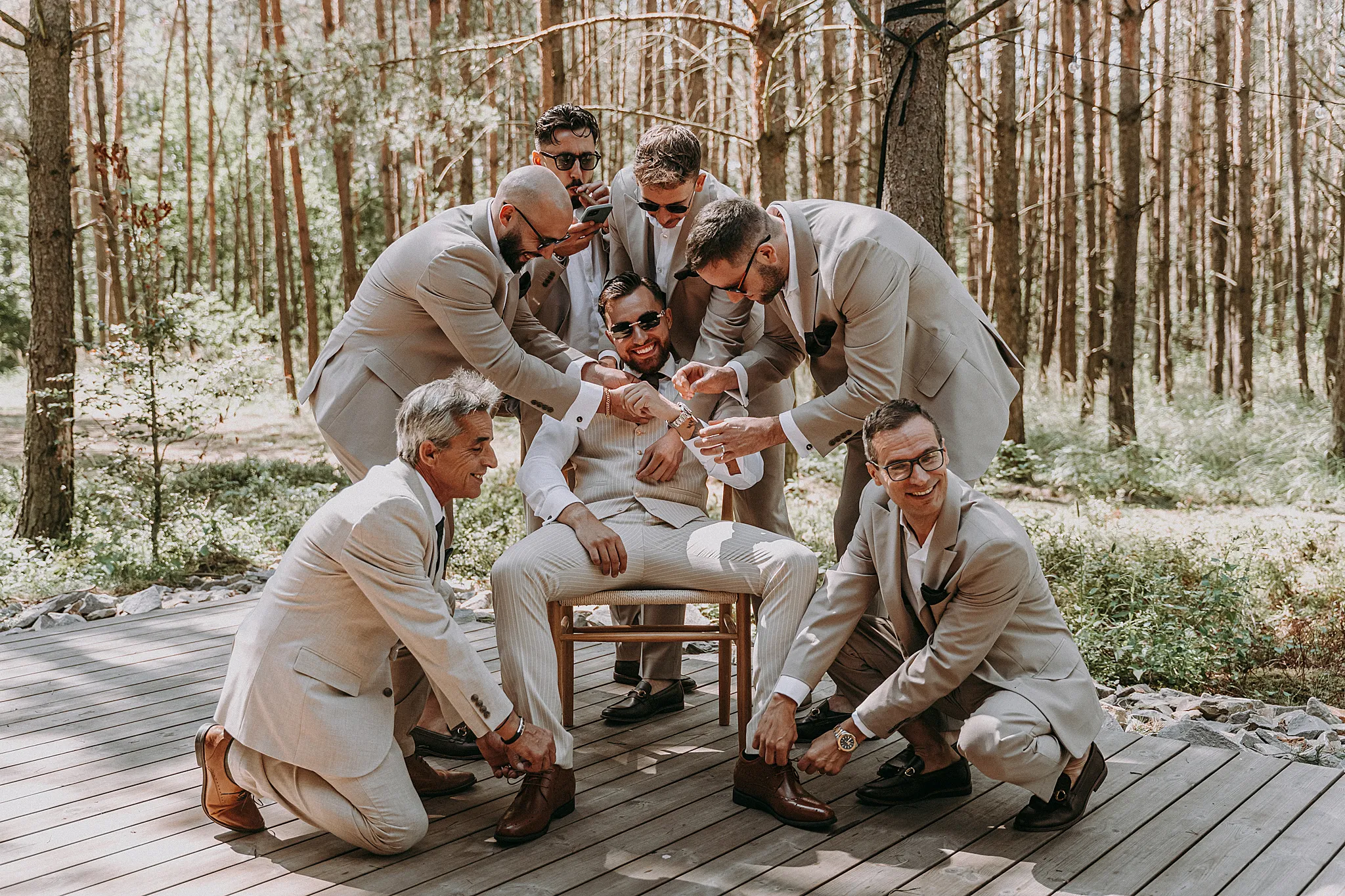 Pan młody z drużbami przed wejściem do drewnianego domku w Zatoce Bajka w obiektywie Studio Grygierczyk