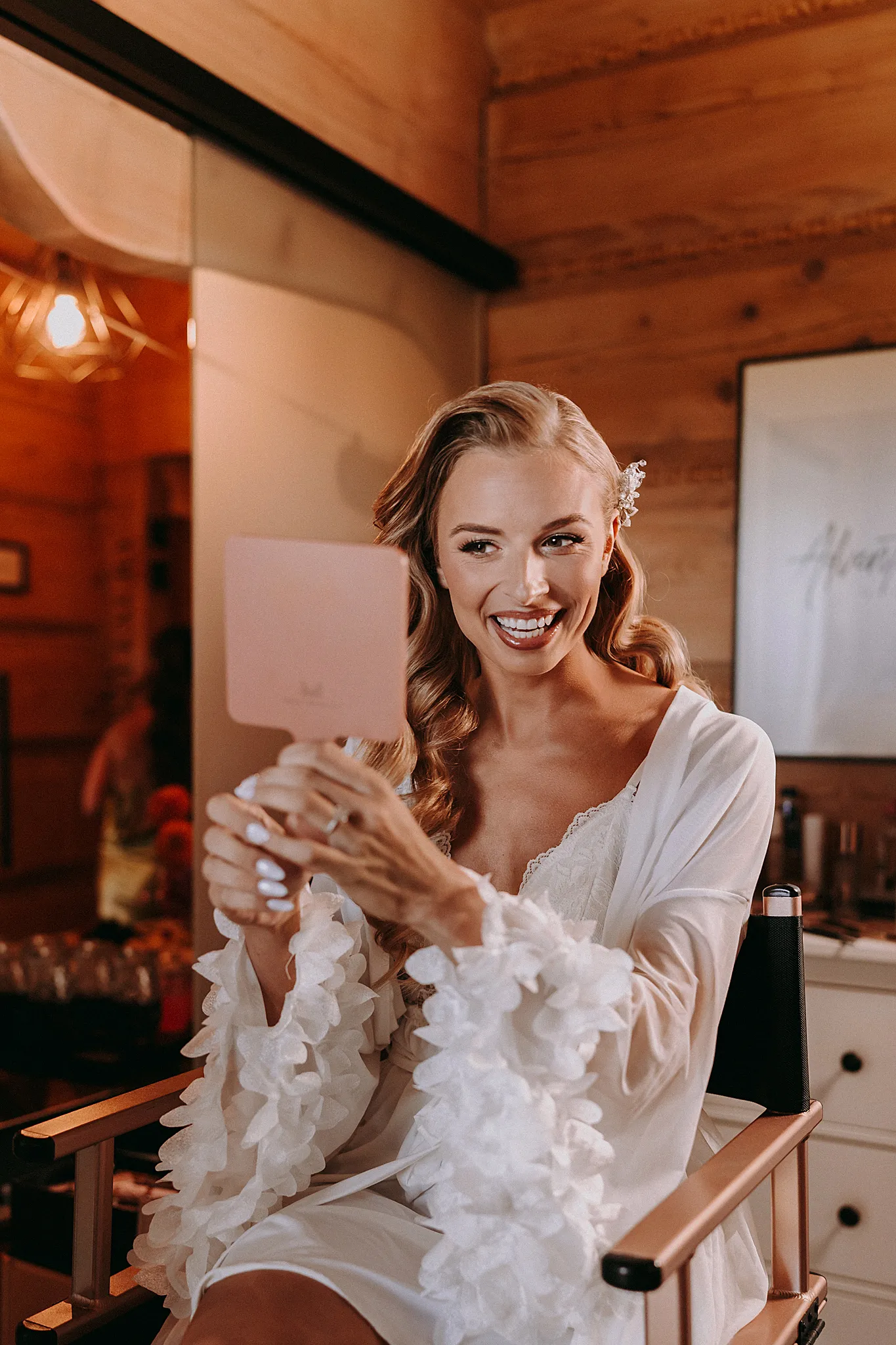 Panna młoda uśmiecha się podczas makijażu w jasnym wnętrzu domku w Hotelu Bajka – fot. Studio Grygierczyk