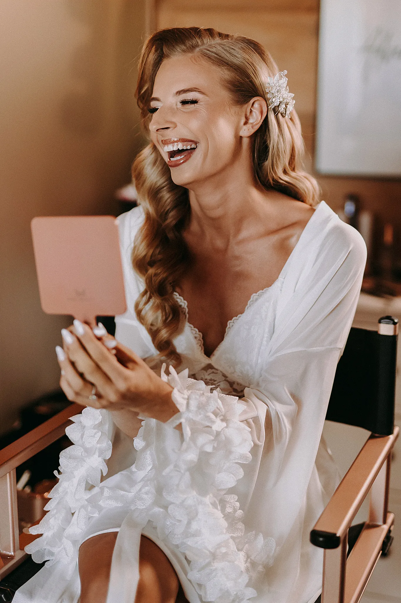 Panna młoda uśmiecha się podczas makijażu w jasnym wnętrzu domku w Hotelu Bajka – fot. Studio Grygierczyk