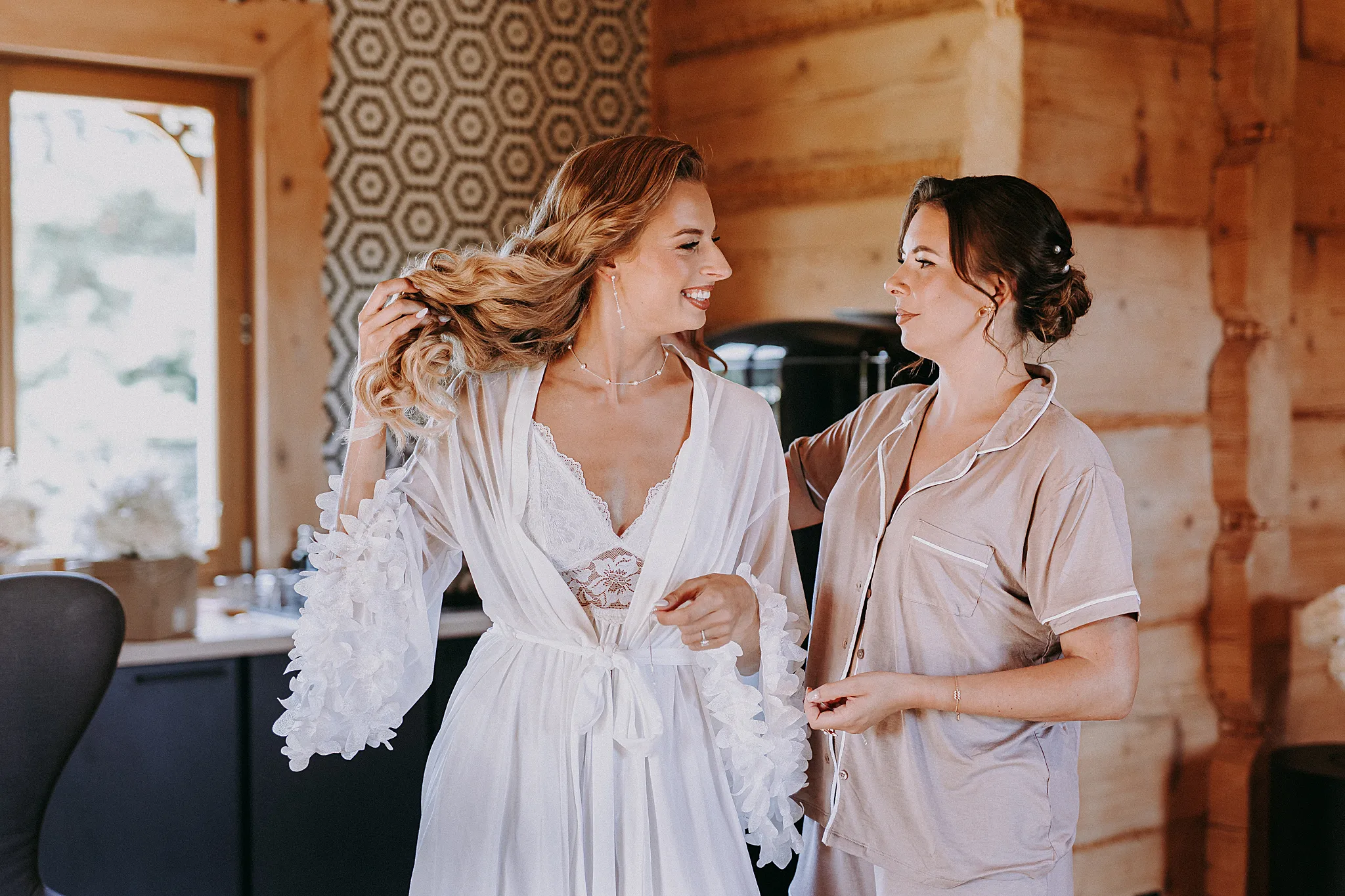 Panna młoda uśmiecha się podczas makijażu w jasnym wnętrzu domku w Hotelu Bajka – fot. Studio Grygierczyk