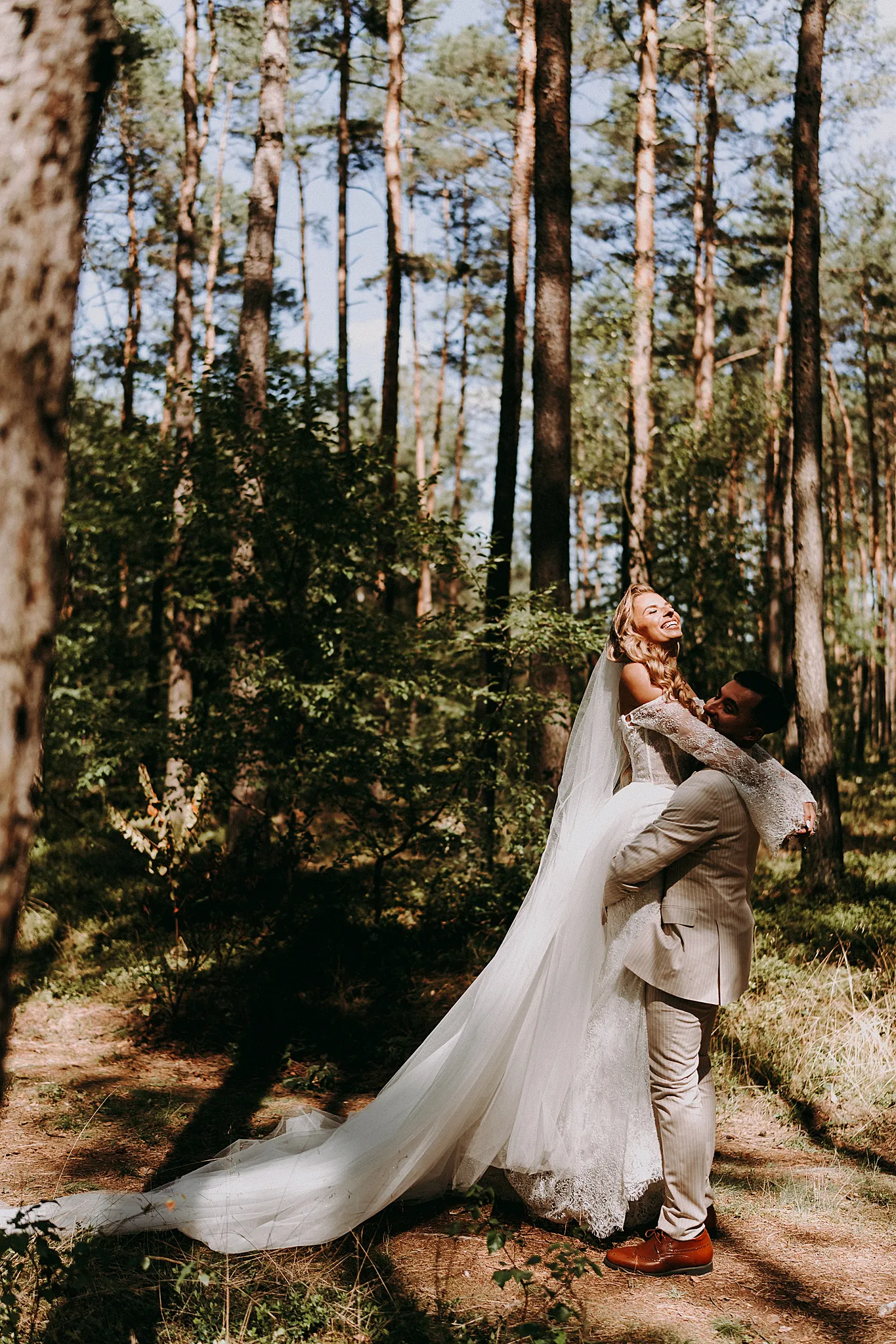 Dynamiczne ujęcie pary młodej w okularach, uchwycone w pełnym słońcu w otoczeniu zieleni Hotelu Bajka