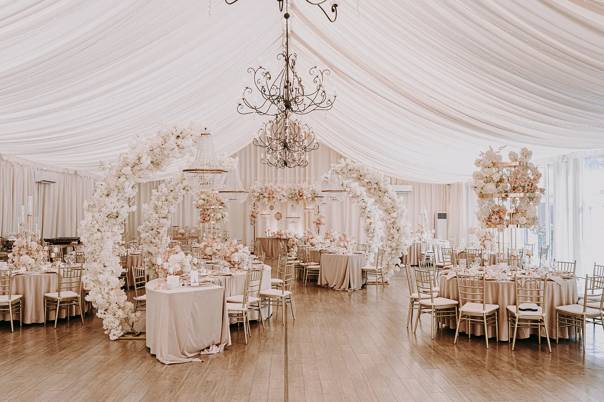 Świetliste wnętrze sali weselnej w Hotelu Bajka z eleganckimi okrągłymi stołami i kolorowymi girlandami kwiatowymi – fot. Studio Grygierczyk