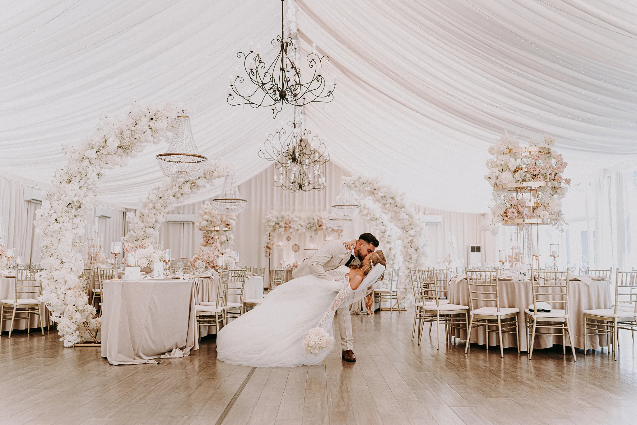 Spontaniczna reakcja nowożeńców na widok kolorowych girland i nakrytych stołów w świetlistym wnętrzu Zatoki Bajka