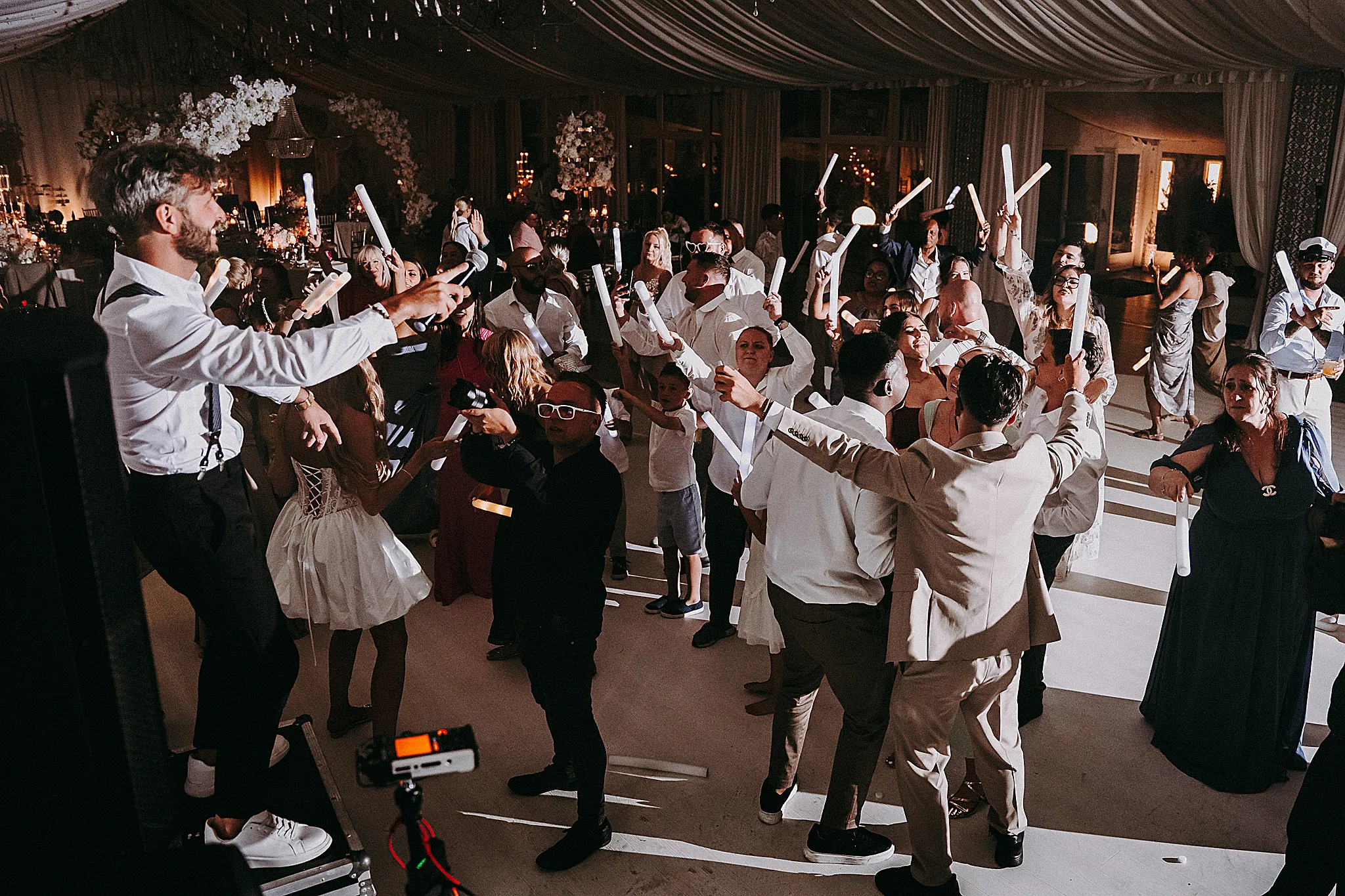Tłum gości weselnych z rękami w górze, bawiący się w rytm muzyki w Hotelu Bajka – ujęcie pełne energii od Studio Grygierczyk