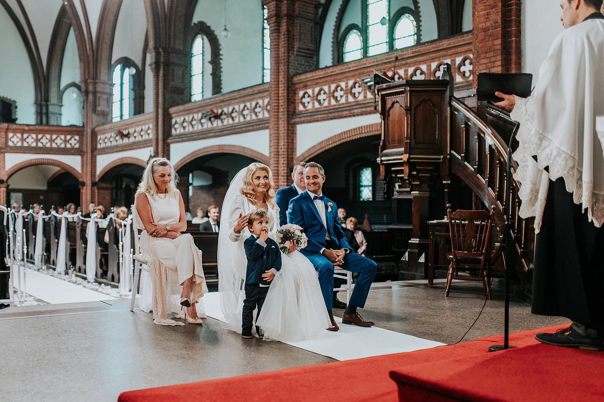 para mloda w kosciele podczas cermoni z radossnymi zaciekawionym synem stojacym obok matki. Kościół Rzymskokatolicki pw. św. Anny w zabrzu