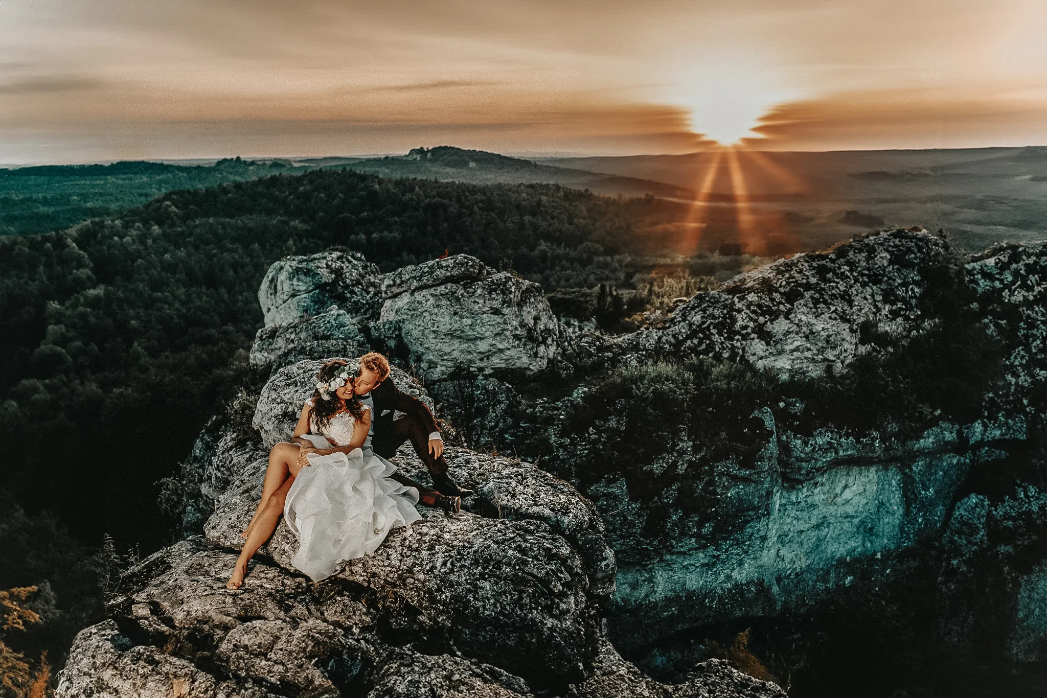 mloda para na szczycie gory w klimatycznym uscisku i niewymuszonej pozie na tle zachodzacego slonca . autentyczna fotografia hybrydowa żory