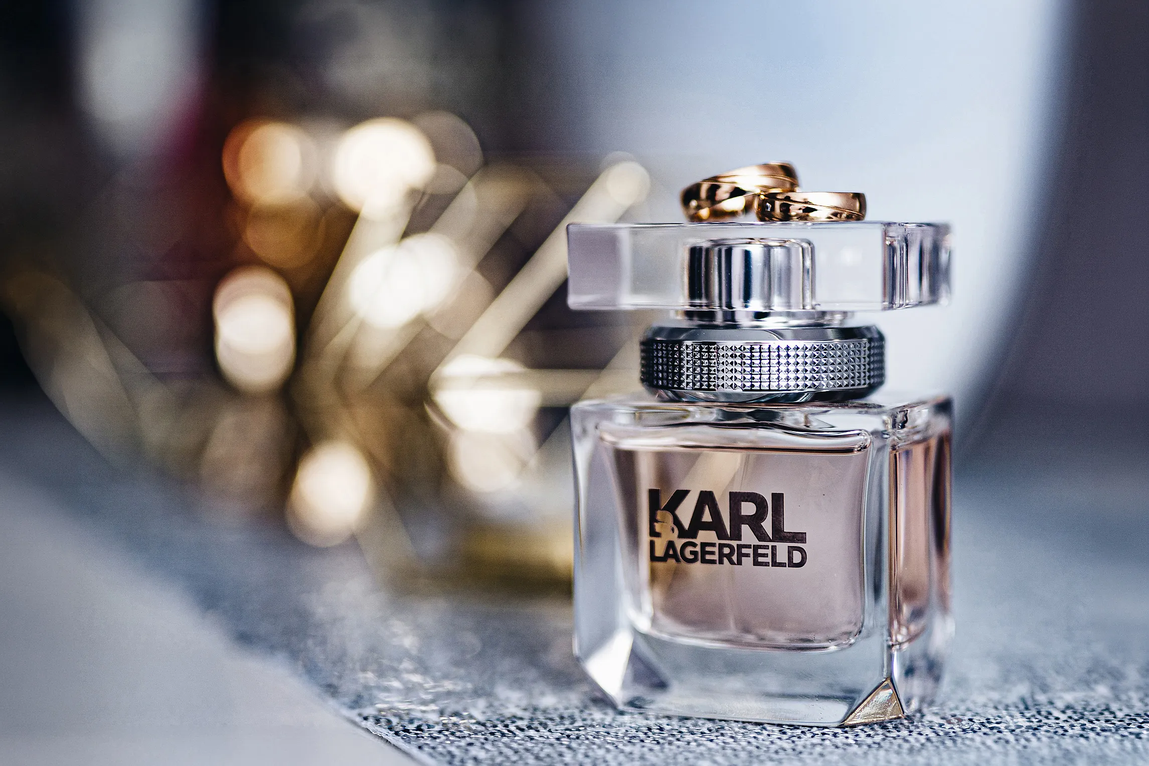 slubne obraczki pokazane na markowym perfumie podczas przygotowan mlodej pani w pastelowych barwach