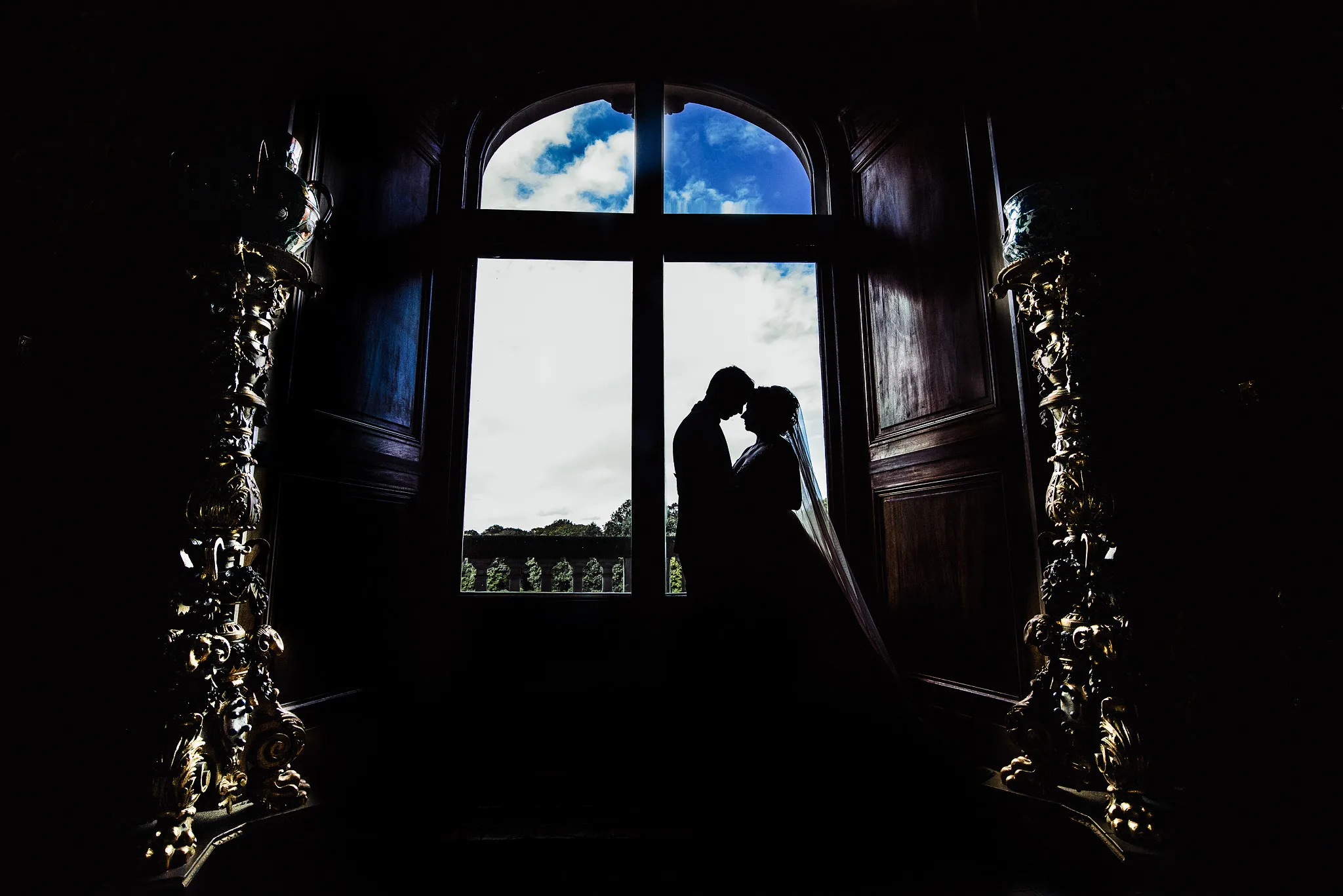 klimatycnze konturowe ujecie mlodej pary na tle zabytkowego okna wpalacu w pszczynie studio grygierczyk dyskretne zdjecia slubne