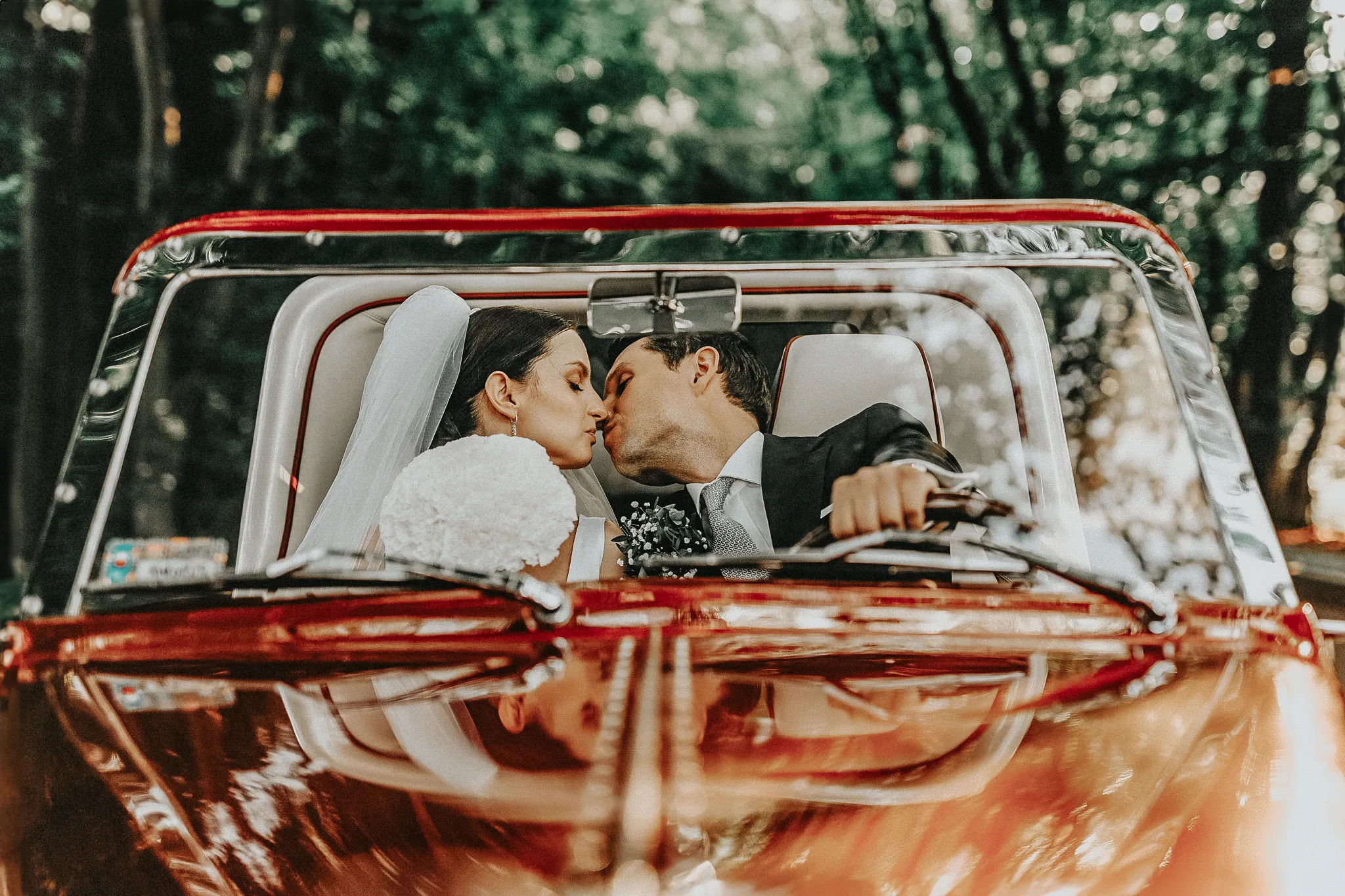 para mloda w pocalunku w samochodzie retro Reportaż hybrydowy: spójny film i zdjęcia z Twojego wesela, Studio Grygierczyk krakow