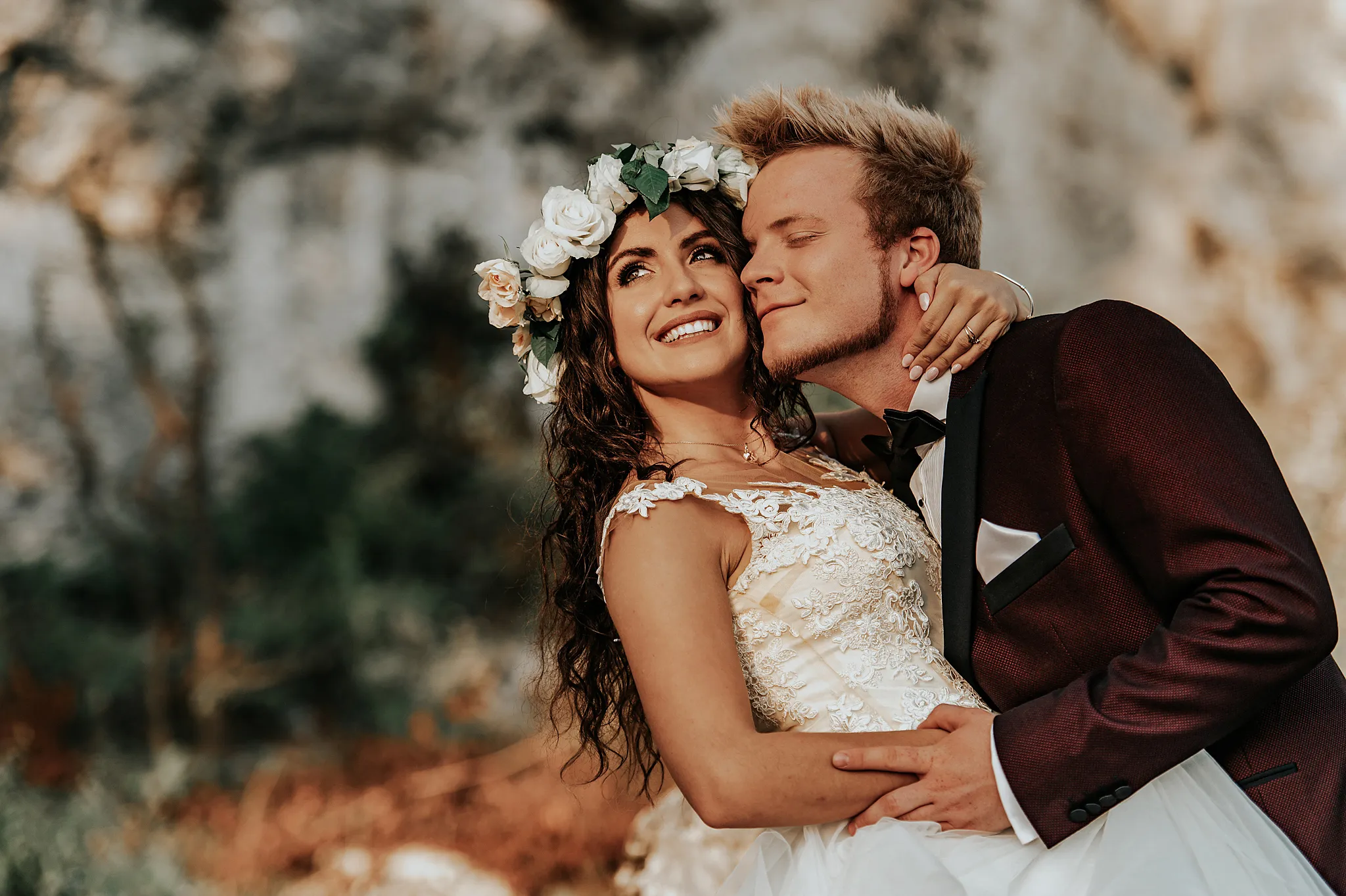 pani mloda z wiankiem kwiatowym i rozpuszczonymi wlosami na sesji w gorach. cieply zachod slonca